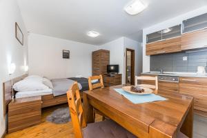 a kitchen and dining room with a table and a bed at Mountain Villas Polana in Nový Smokovec
