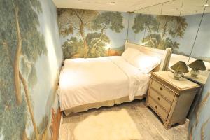 1 dormitorio con 1 cama y una pintura en la pared en Tenderness at Notre Dame, DELACROIX, en París