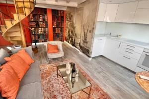 una sala de estar con un sofá y una mesa en Rooftop Triplex with Garden at Notre Dame, en París