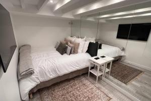 Un dormitorio con una gran cama blanca con espejo. en Rooftop Triplex with Garden at Notre Dame, en París