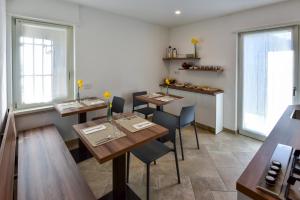 a restaurant with wooden tables and chairs and windows at B&B Al Lupo Solitario in Segonzano