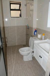 Amalia apartments syokimau near JKIA في نيروبي: حمام به مرحاض أبيض ومغسلة