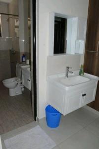 Amalia apartments syokimau near JKIA في نيروبي: حمام مع حوض أبيض ومرحاض