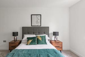 1 dormitorio con 1 cama grande con almohadas verdes en Modern 2 bed 2 bath apartment in the heart of York en York