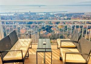 two chairs and a table on a balcony with a view at Sunflower Sky Apartment in Rijeka