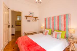 una camera da letto con un grande letto bianco con cuscini colorati di Be Local - Flat with one bedroom in Moscavide - Lisboa a Lisbona
