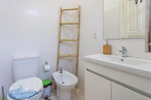 a white bathroom with a toilet and a sink at Be Local - Flat with one bedroom in Moscavide - Lisboa in Lisbon