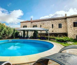 una grande piscina blu di fronte a un edificio di Borgo Antico XIX sec. a Gesturi