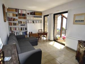 a living room with a couch and a book shelf at Maison Arzon, 6 pièces, 11 personnes - FR-1-639-29 in Arzon