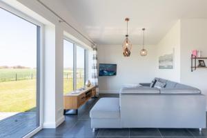 ein Wohnzimmer mit einem Sofa und einem großen Fenster in der Unterkunft Hannes Huis in Neukirchen