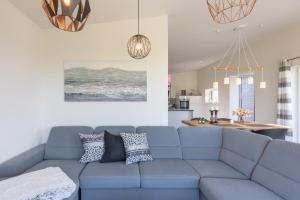 ein Wohnzimmer mit einem blauen Sofa und einer Küche in der Unterkunft Hannes Huis in Neukirchen