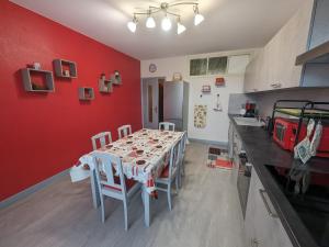 kuchnia ze stołem i czerwoną ścianą w obiekcie Gîte Montot-sur-Rognon, 3 pièces, 4 personnes - FR-1-611-101 