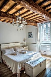 um quarto com uma cama grande e um lustre em La Casa Bianca with parking and view em Orvieto
