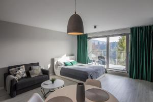 um quarto com uma cama e uma sala de estar com uma grande janela em Apartview Bukowa II by Rent like home em Wisla