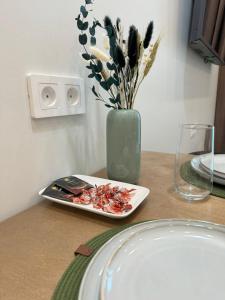 a table with a plate of food and a vase with flowers at A-Six Apartment luxury in Karagandy