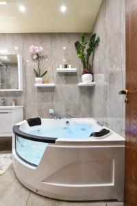 a bathroom with a tub with flowers on the wall at Olive Coast Apartments in Herceg-Novi