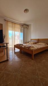 duże łóżko w pokoju z dużym oknem w obiekcie Apartments Mare w Ulcinju