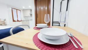 un tavolo con due piatti e bicchieri sopra di Blue Eyes by Ca-Sa Check a Chioggia Altre 11 foto