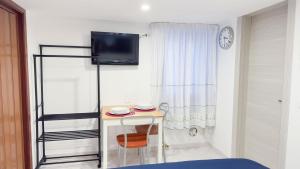 una stanza con un tavolo e una TV su una parete di Blue Eyes by Ca-Sa Check a Chioggia