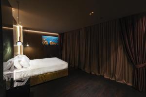 a bedroom with a bed with white sheets at Hotel Touring in Ferrara