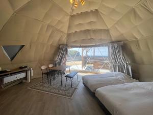 a room with two beds and a table in a tent at 8point resort Awaji in Awaji