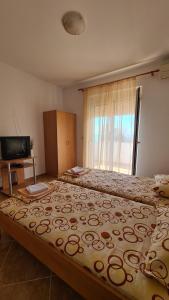 a bedroom with two beds and a television at Apartments Mare in Ulcinj