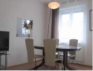 a dining room with a table and chairs and a television at Sweet Home in Friedrichshafen +2 photos