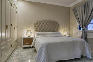 a bedroom with a large bed and two lamps at Casa Natalie La Marina in Puerto Calero