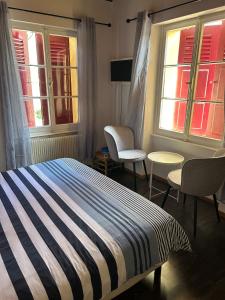 Ferrette的住宿－Chambres d'Hôtes Le Felseneck - NOUVEAU PROPRIÉTAIRE - NEW MANAGEMENT，一间卧室配有一张床、两把椅子和窗户