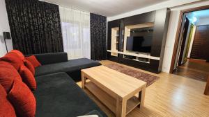 a living room with a couch and a television at Apricot Blossom Otopeni in Otopeni