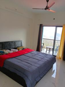 a bedroom with a bed and a large window at Western Valley Cottages , Panchagani in Panchgani