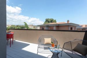 un patio con sedie e un tavolo sul balcone. di Ollen apartments a Catania