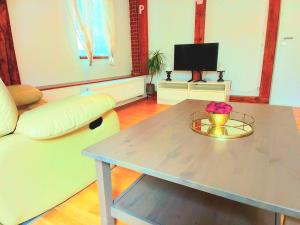 een woonkamer met een tafel en een televisie bij Apartmán Penelope in Žatec