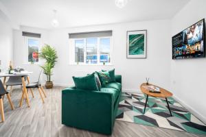 uma sala de estar com um sofá verde e uma mesa em 2 Bedroom Deluxe Apartment - Secure Parking - Wifi - Netflix - 27C em Sleightholme
