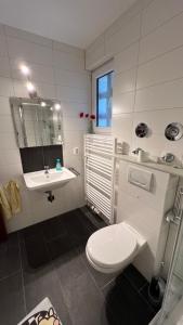 a white bathroom with a toilet and a sink at Ferienwohnung Lea in Bad Reichenhall
