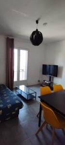 een woonkamer met een bed en een tafel en stoelen bij Appartement lumineux in Montreuil