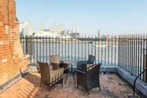 a balcony with a table and chairs and a view of the water at 3 x Bedroom Riverside Flat with Beach in London
