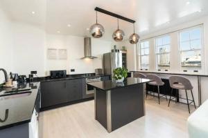 a kitchen with black and white appliances and a counter at 3 x Bedroom Riverside Flat with Beach in London