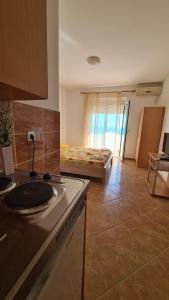 a kitchen with a stove and a room with a bed at Apartments Mare in Ulcinj