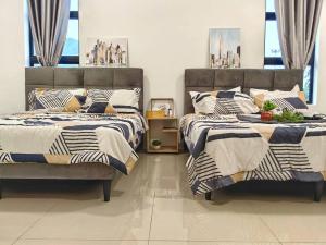 two beds sitting next to each other in a bedroom at 15-19Pax SemiD Near Highwy W/Pool Table&Karaoke in Ipoh