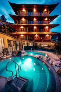 a hotel with a swimming pool in front of a building at Hotel Hochschober in Ebene Reichenau