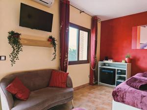 a living room with a couch and a tv on the wall at Finca Oliva in Bolulla