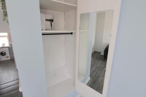 a white kitchen with white cabinets and a door at Beautiful 1 Bedroom Central Flat in Leamington Spa