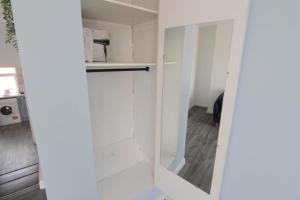 a white kitchen with white cabinets and a door at Spacious 1 Bedroom Central Flat in Leamington Spa