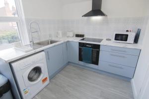 a kitchen with a washing machine and a sink at Beautiful 1 Bedroom Central Flat in Leamington Spa