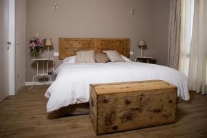 サン・ジョヴァンニ・ルパトートにあるLa Corte Di Anna Agriturismoのベッドルーム1室(大型ベッド1台、木製ヘッドボード付)