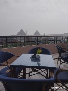 een tafel en stoelen op een balkon met uitzicht bij Sneferu Pyramids inn - Full Pyramids View in Caïro