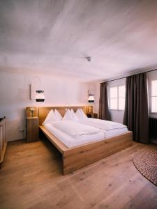 a bedroom with a large bed with white sheets at artHotel Blaue Gans in Salzburg