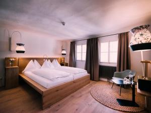 a bedroom with a large bed and a large window at artHotel Blaue Gans in Salzburg
