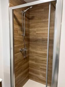 eine Dusche mit einer Holzwand im Bad in der Unterkunft Apartamento céntrico con vistas in Santiago de Compostela